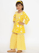 Woman wearing a yellow indian kurti for women by Nishtha Chadda