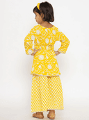 Woman wearing a yellow indian kurti for women by Nishtha Chadda