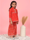 Woman wearing a red indian kurti for women by Nishtha Chadda