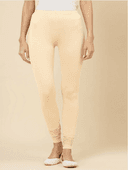 Woman wearing a beige kurti set with dupatta by Nishtha Chadda