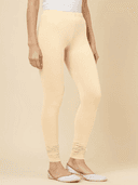 Woman wearing a beige kurti set with dupatta by Nishtha Chadda