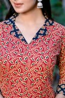 Woman wearing a red kurti set with dupatta by Nishtha Chadda