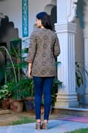 Woman wearing a red kurti set with dupatta by Nishtha Chadda
