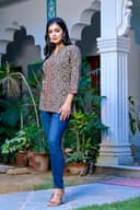 Woman wearing a red kurti set with dupatta by Nishtha Chadda