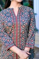 Woman wearing a red kurti set with dupatta by Nishtha Chadda