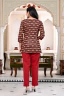 Woman wearing a maroon kurti set with dupatta by Nishtha Chadda