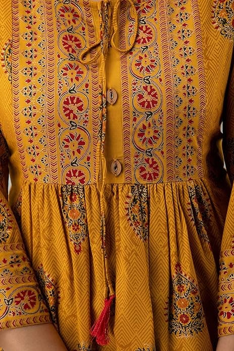 Woman wearing a orange party wear ethnic kurta style by Nishtha Chadda
