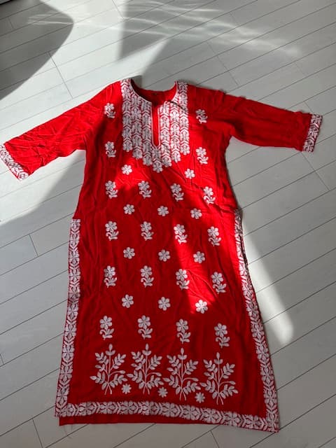 Woman wearing a red embroidered kurti set by Nishtha Chadda