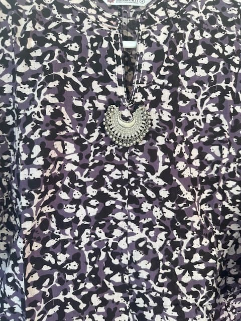 Woman wearing a purple embroidered kurti set by Nishtha Chadda