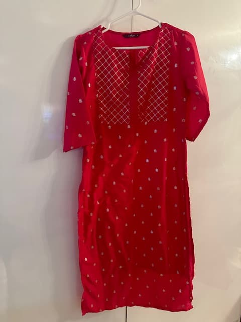 Woman wearing a red embroidered kurti set by Nishtha Chadda
