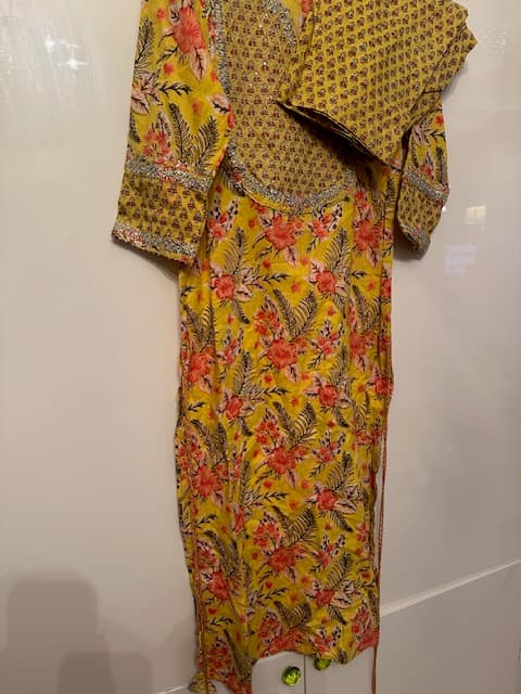 Woman wearing a brown embroidered kurti set by Nishtha Chadda