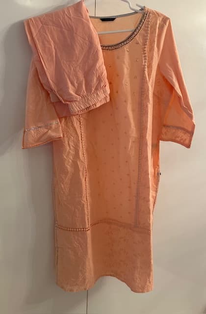 Woman wearing a brown embroidered kurti set by Nishtha Chadda