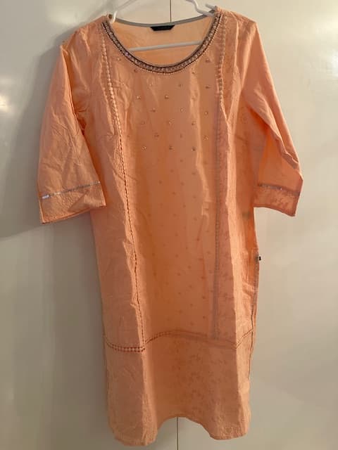 Woman wearing a brown embroidered kurti set by Nishtha Chadda