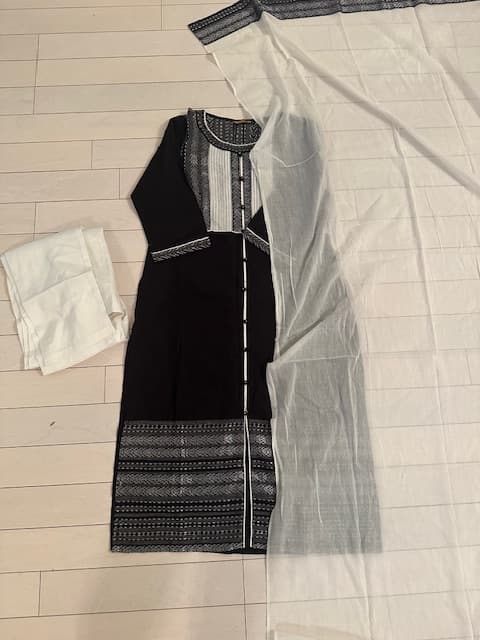 Woman wearing a beige embroidered kurti set by Nishtha Chadda