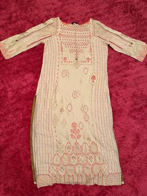 Woman wearing a maroon embroidered kurti set by Nishtha Chadda