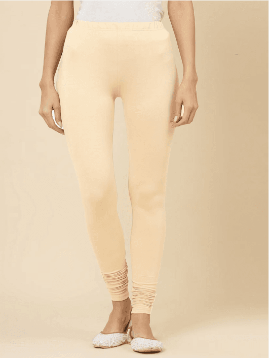 Woman wearing a beige kurti set with dupatta by Nishtha Chadda