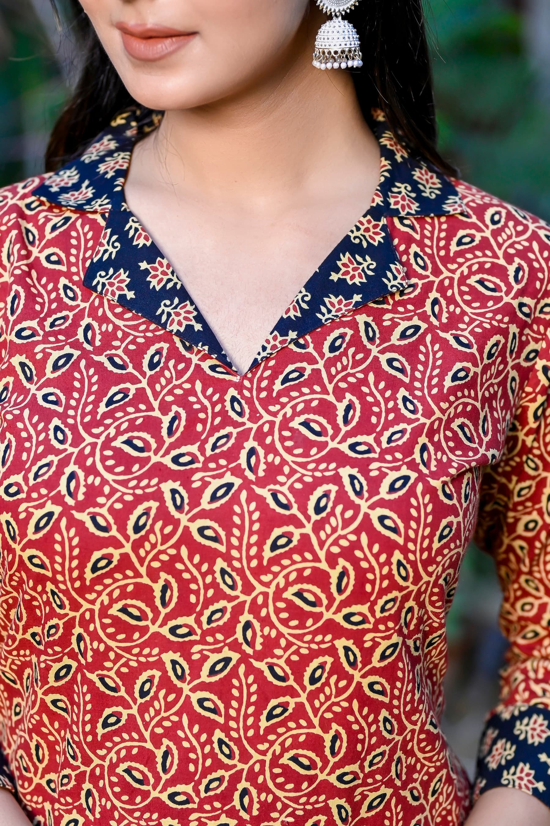 Woman wearing a red kurti set with dupatta by Nishtha Chadda